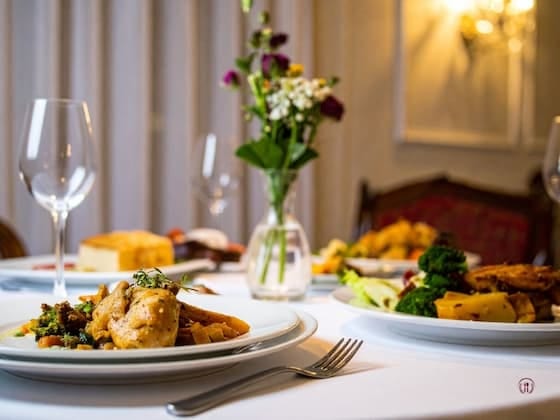 Nakryty stół z eleganckim daniem i winem w restauracyjnym wnętrzu.