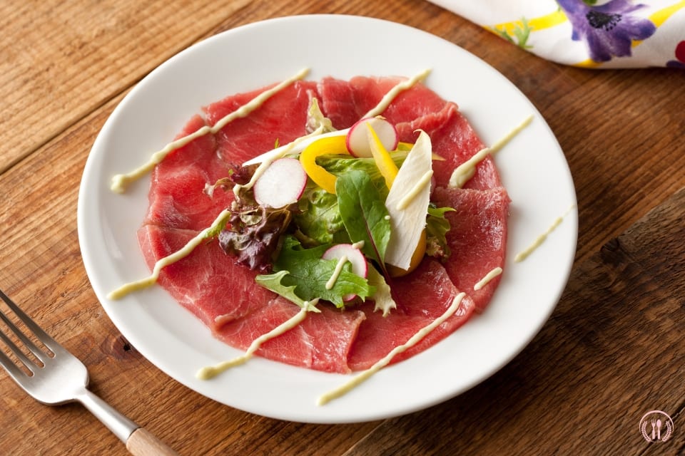 Cienkie plastry wołowiny z rukolą, oliwą truflową i marynowanymi kaparami.